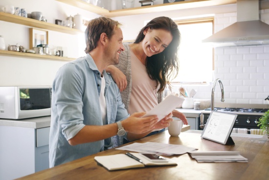 Couple, happy and tablet with documents at house for financial planning, bank balance and debt payment. Man, woman and paperwork for budget savings, property insurance and credit score of mortgage