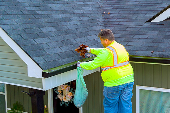 roofer working at gutters. Roof inspection after the storm. 