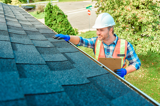 roofer checking gutters and siding before the storm. Roof inspection. 